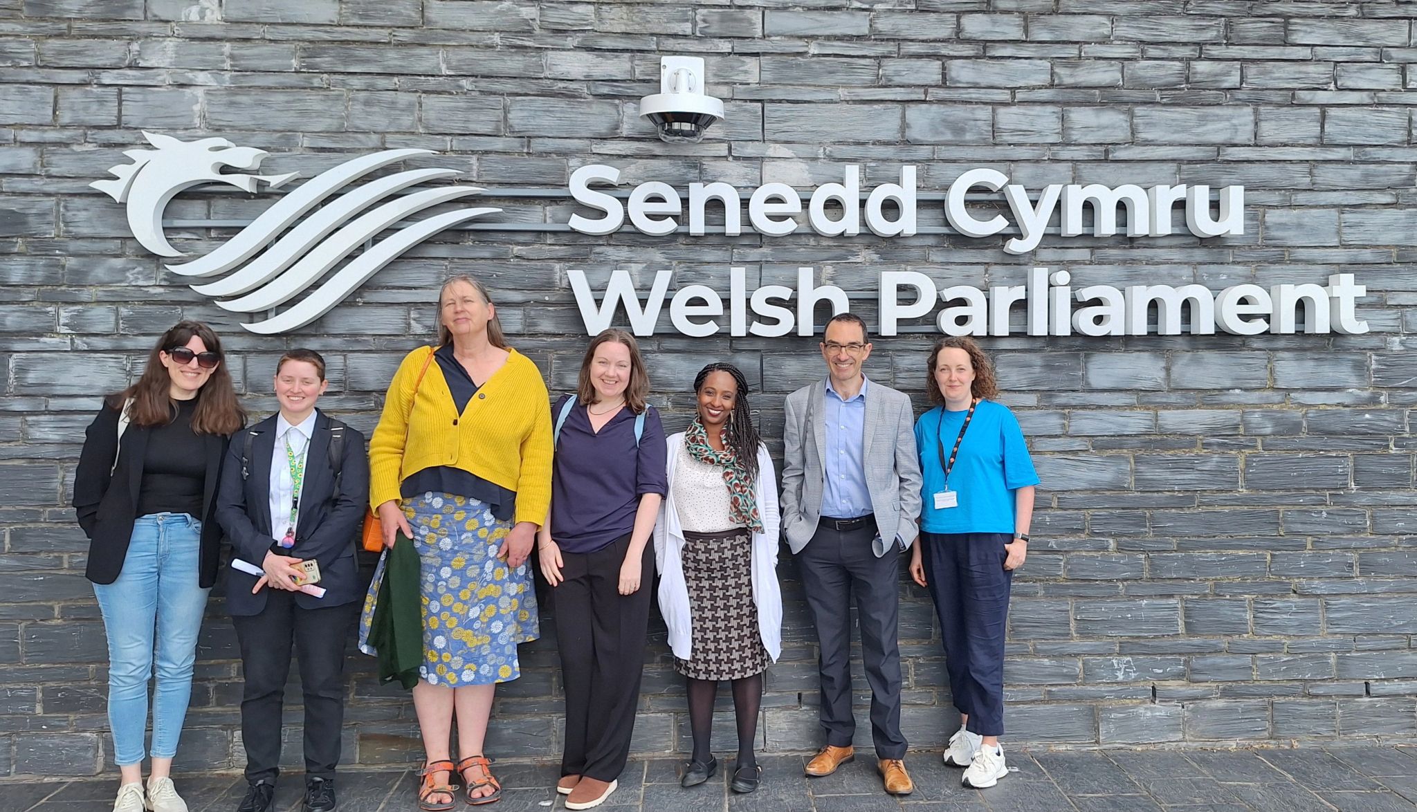 Members of y twndis standing outside the senedd building