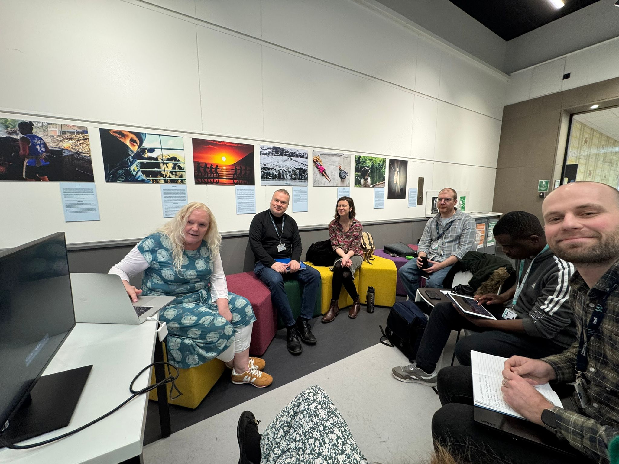 A group of people sat together looking at a laptop