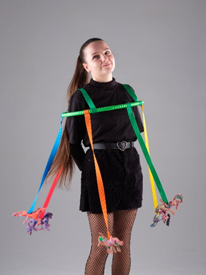 Girl dressed in black wearing horse brooches on ribbon on a hoop