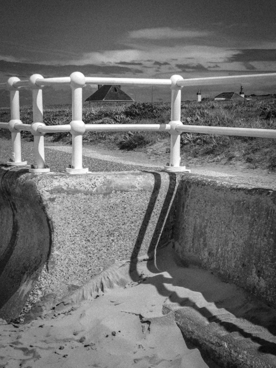 Beach wall, sand and railing