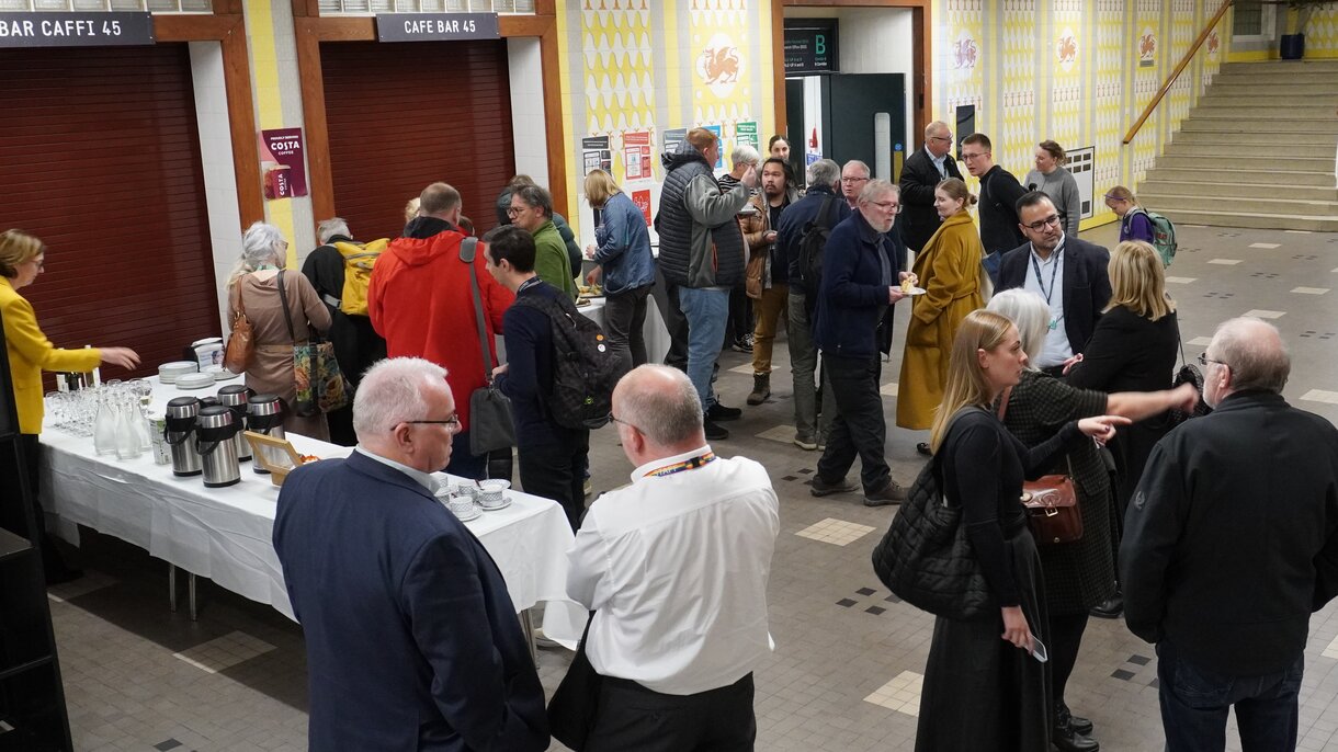 People chatting at the food and drink reception in the foyer