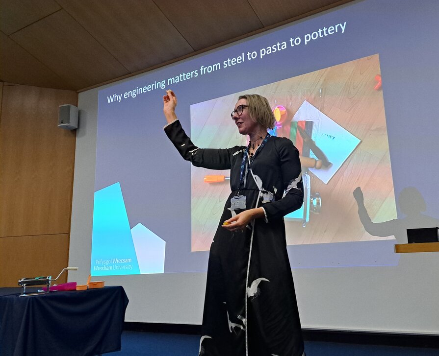 Anne holding up a piece of pasta at her inaugural lecture