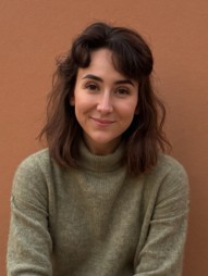 Head and shoulders shot of catrin in a turtleneck sweater smiling
