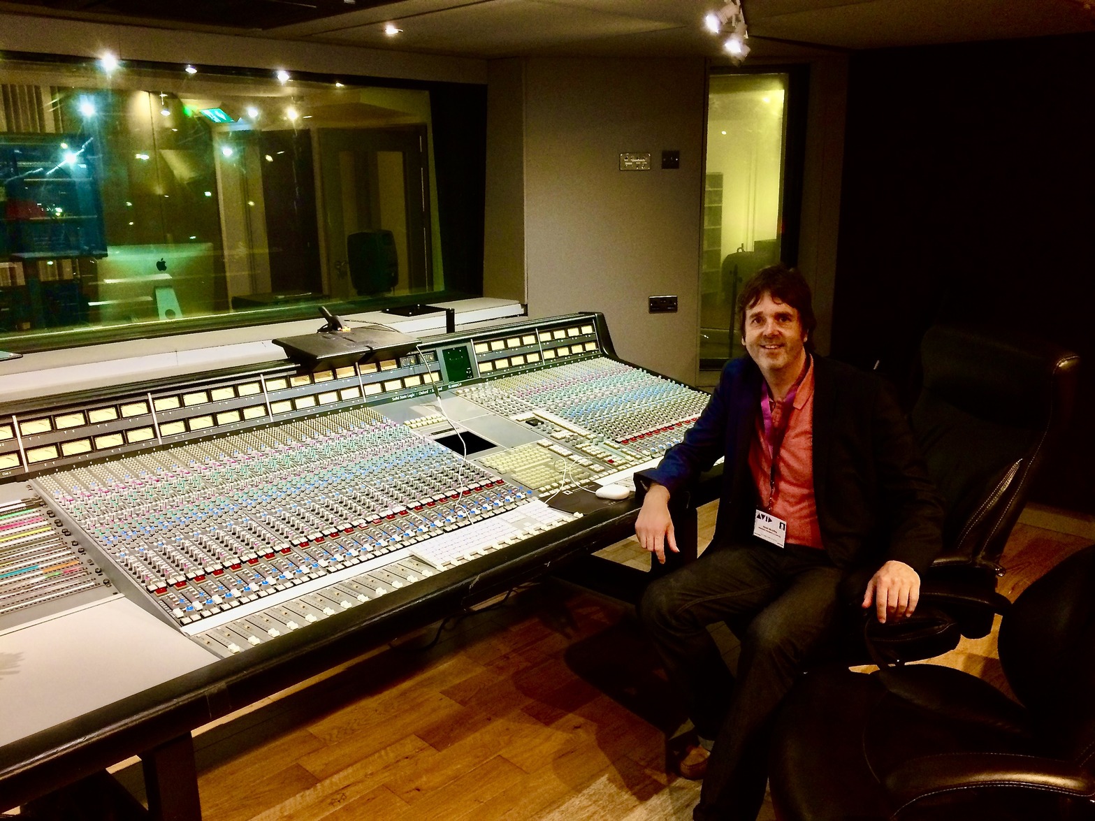 Person in a suit sitting at a recording mixing desk