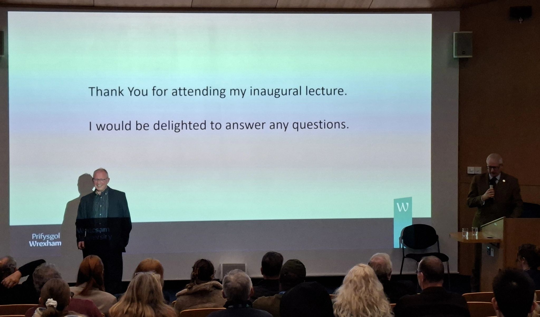 Person in front of a large presentation screen talking to an audience