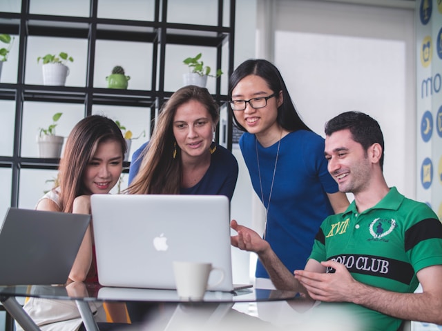 a group of people looking at a laptop screen