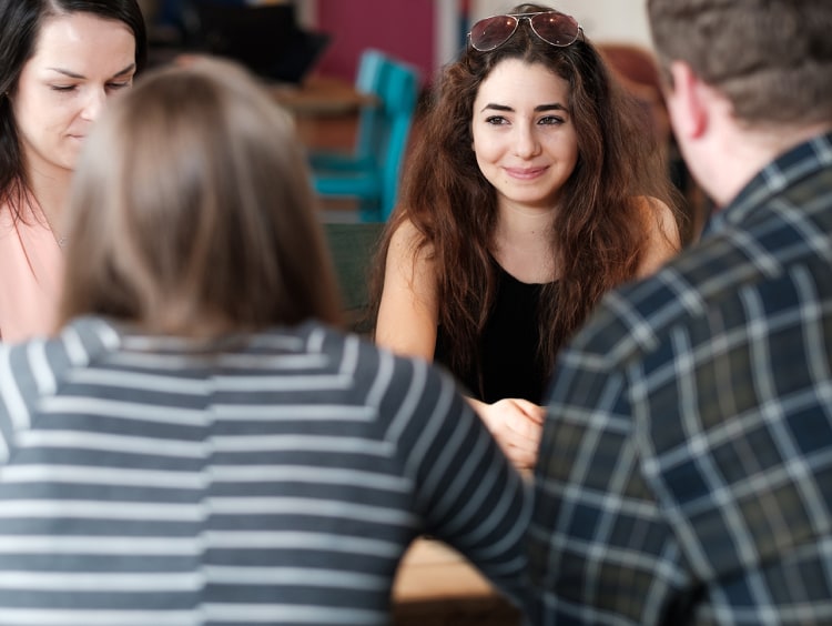 Four students chatting around a table